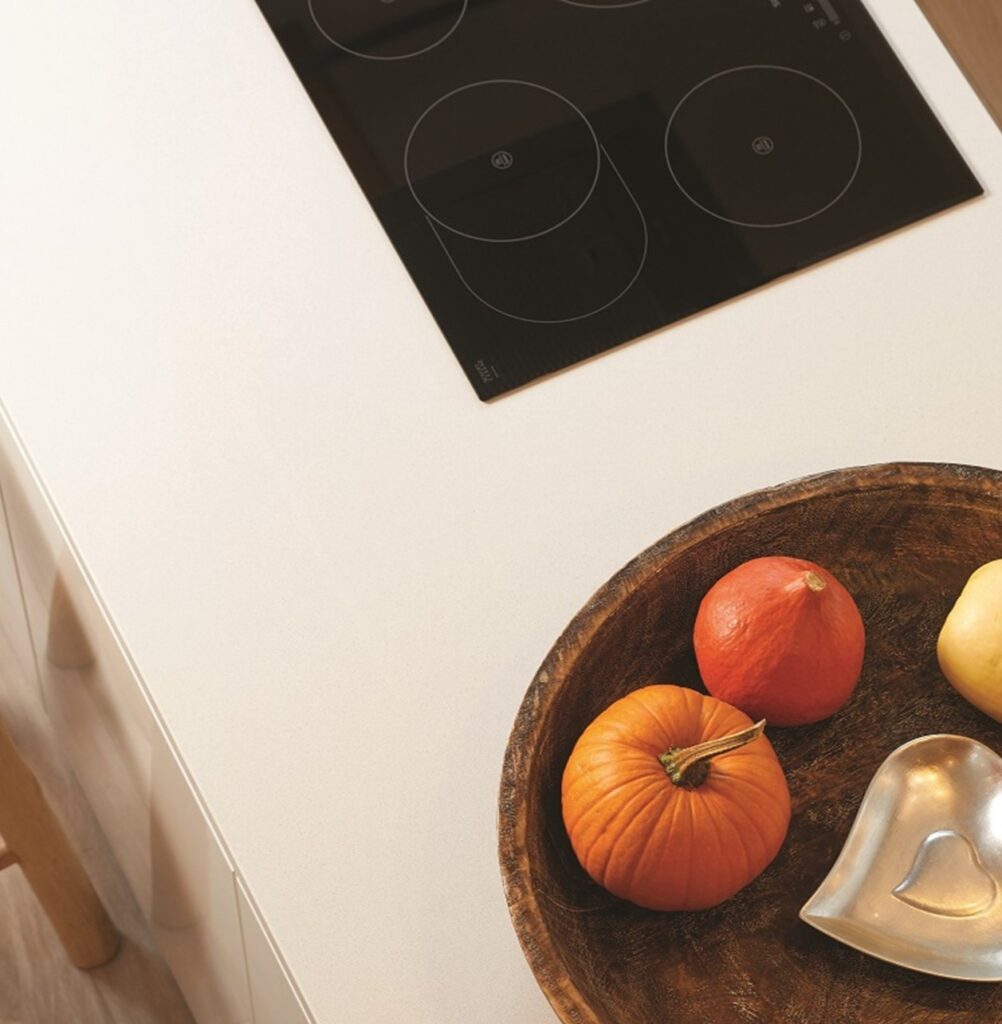 Technistone Crystal Diamond countertop with a light base and fine sparkling particles, polished glossy finish and black cooktop circles