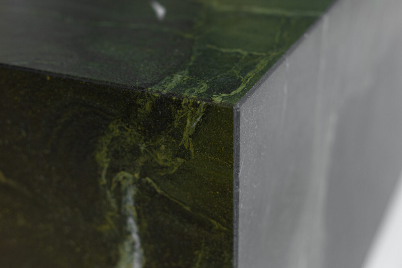 Roheline marmorist serv ja servaäärne detail, tumedate roheliste veenidega, elegantne kivimaterjal.