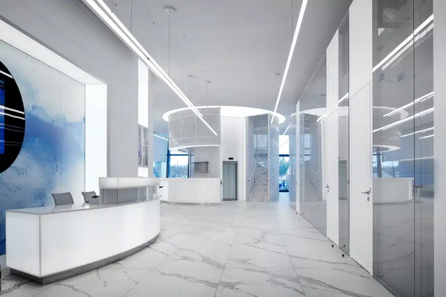 Bright, modern office lobby with Bianco Statuario Venato marble flooring and a curved reception desk.