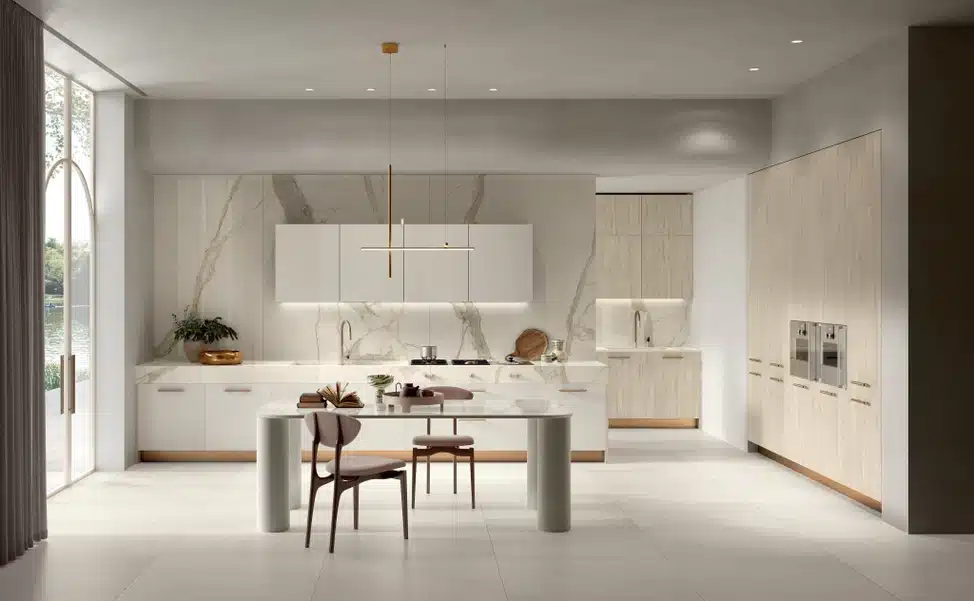 Modern kitchen with Calacatta Michelangelo marble backsplash, white cabinets, and dining table.