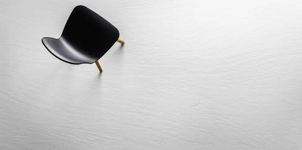 Minimalist black chair on Laminam Ardesia Bianco floor, showcasing a clean, modern design.