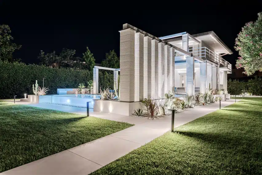 Calce Bianco Laminam viimistlusega valge pinnatöötlusega arhitektuuriline maja õue- ja haljastusega, rõhutades kaasaegset plaaadi ja „calce“ inspireeritud viimistlust