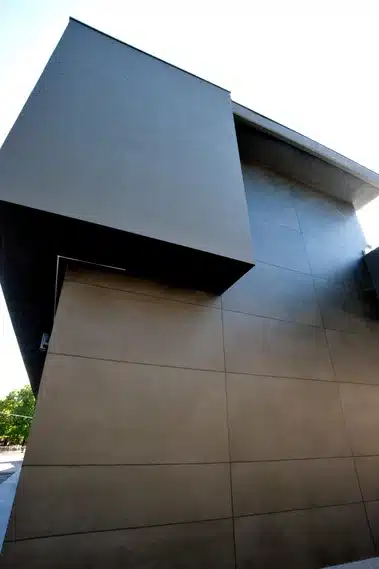 Calce Nero Laminam pind modernse arhitektuuriga hoone külg, tumehall toon, suured plaadid, kaasaegne välimus ja kergelt peegeldav pind.