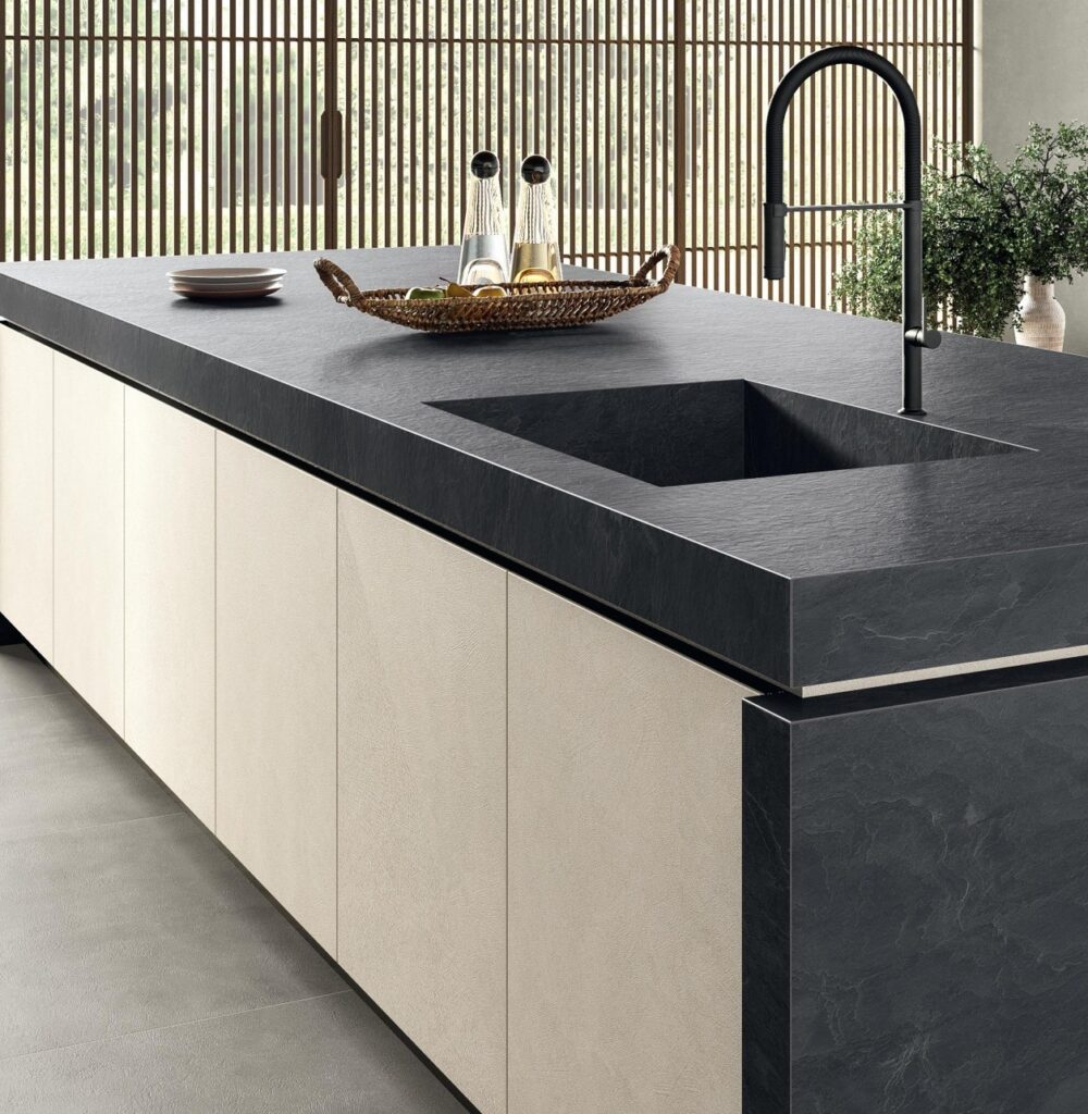 Laminam Vulcano surface on a dark textured stone-effect kitchen countertop with sink, brass-gold accents, and volcanic shadow tones.