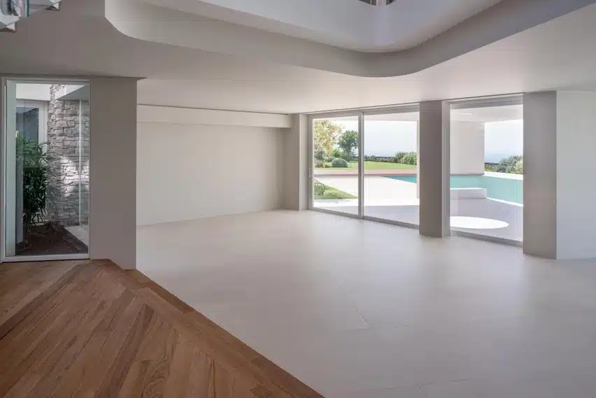 Laminam Calce Avorio värvi kaasaegne, hele ja avar interjöör, suured klaasist seinad ning mööbli minimaalne disain, punaseks sobivate puidust põrandadega.