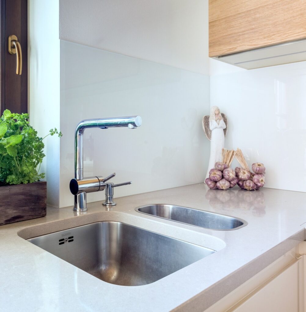 TechniStone Noble Ivory White quartz in ivory to light grey tones with subtle veining and a polished finish in a modern kitchen.