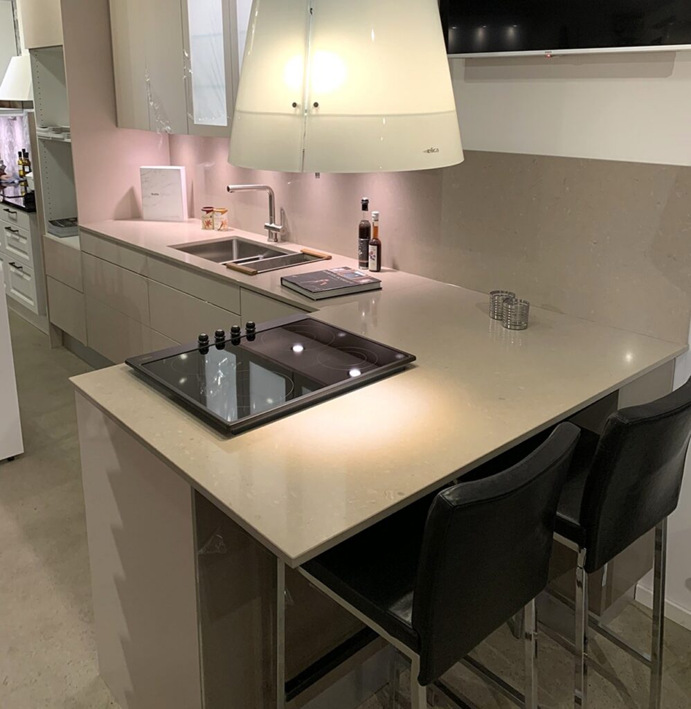 TechniStone Noble Troya quartz surface in a modern kitchen, soft grey polished finish with subtle veining and a glossy, refined look.