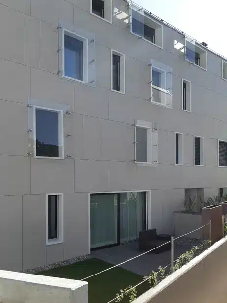 Laminam Sale Fokos tooni beige laminaatpaneelid välisseinal, kaasaegse arhitektuuri hall-beez välimus ja modernne akna- ning ukselahendus.