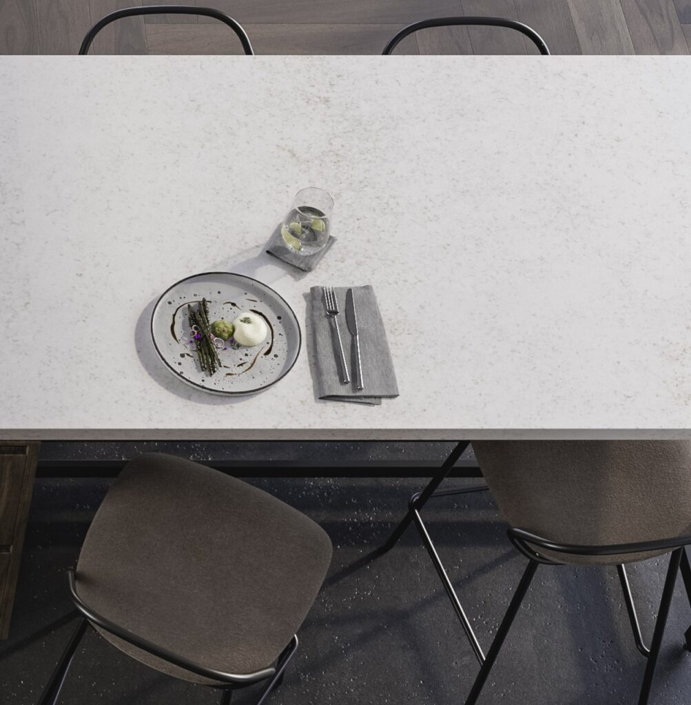 TechniStone Wedding Lily engineered quartz countertop in a light speckled finish, shown with a simple place setting and neatly folded textiles on worktop.