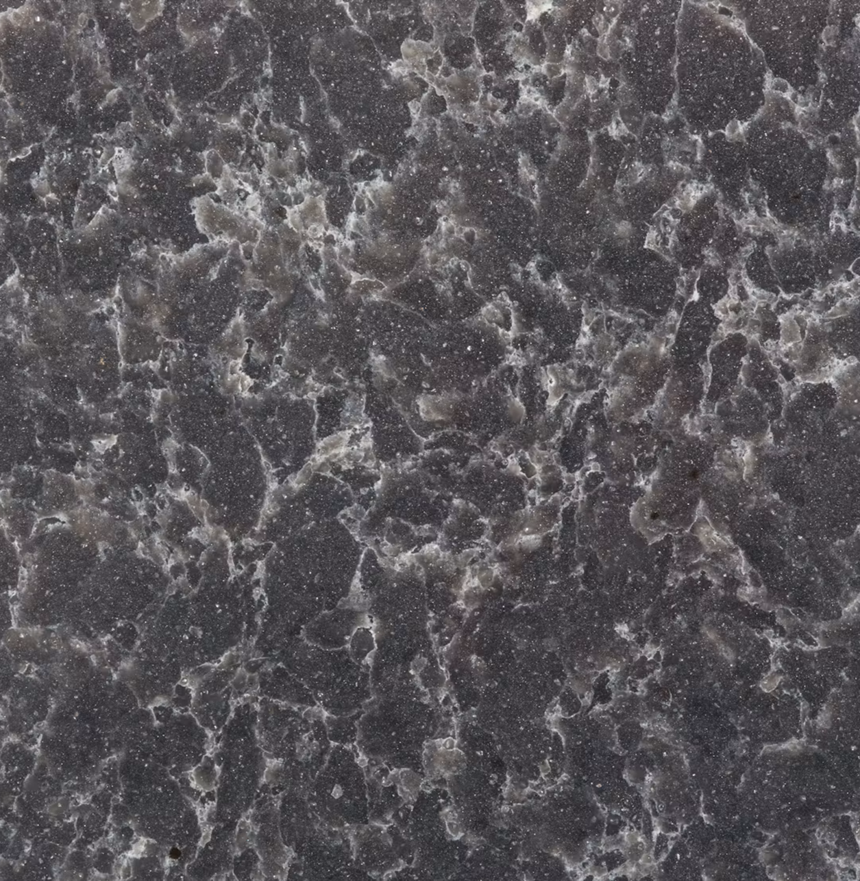 Dark Silestone Ocean Storm quartz surface with flowing white and grey veining, inspired by natural stone and dramatic marble patterns for modern interiors.
