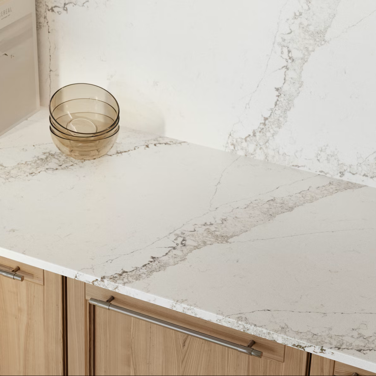 Silestone Calacatta Themis countertop with wooden cabinets and glass bowls