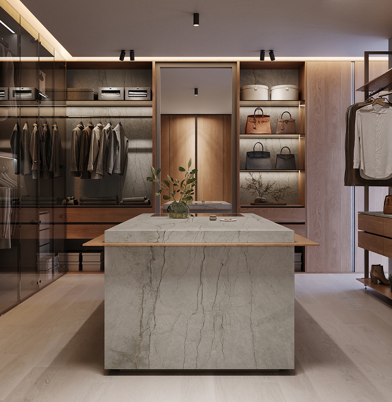 Modern walk-in closet with marble island, hanging clothes, handbags, and built-in lighting.