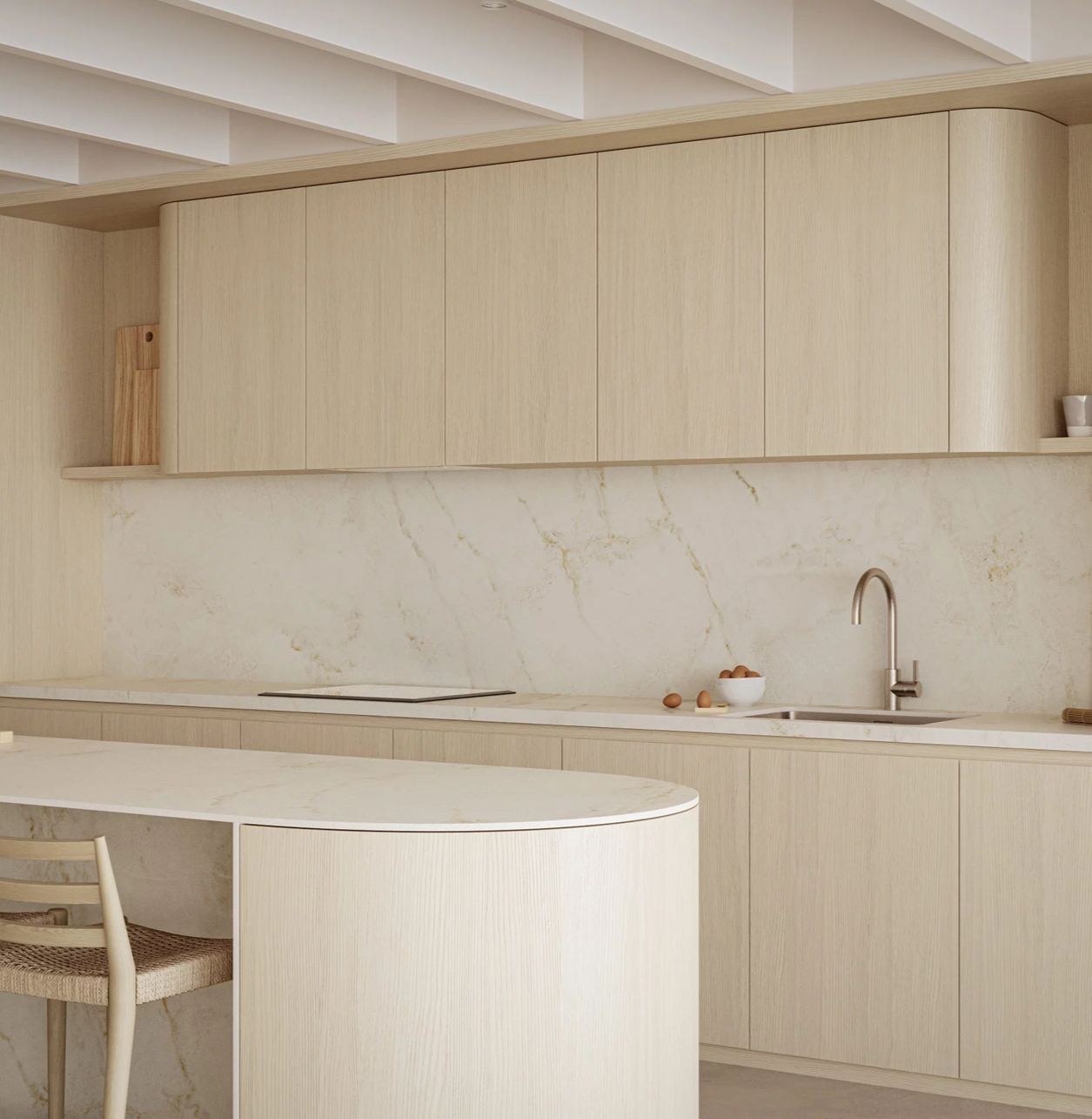 In a warm minimalist kitchen, Caesarstone 537 Glacetta porcelain shows a luminous white surface with soft cream undertones and delicate golden veining.