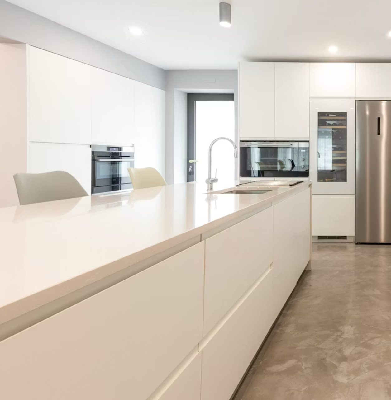 Modern white kitchen with Silestone Yukon island and stainless steel appliances