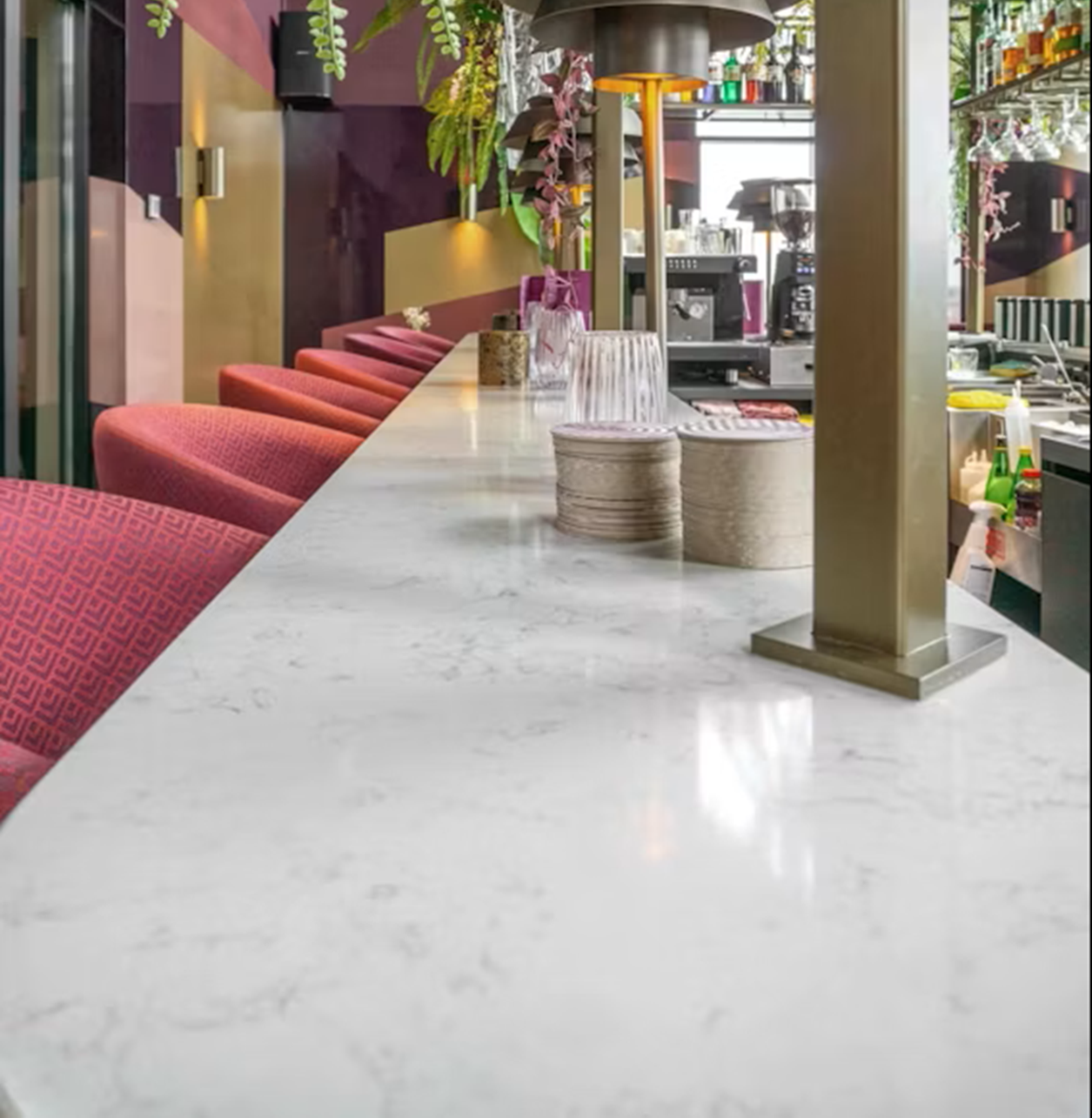 Silestone Lagoon countertop with red bar stools and bar in a modern restaurant.