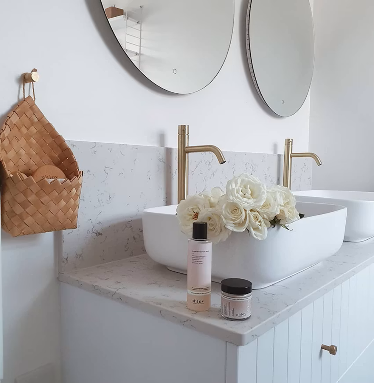 Silestone Lyra countertop in a modern bathroom with double sinks and gold faucets.