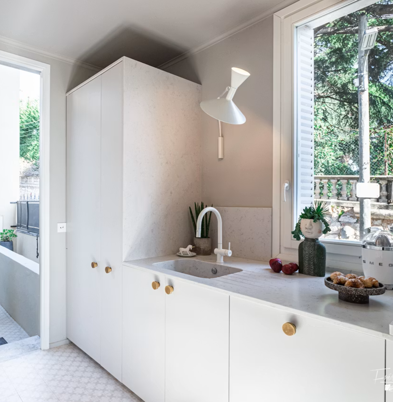 Modern white kitchen with Silestone Lagoon countertops and sink.