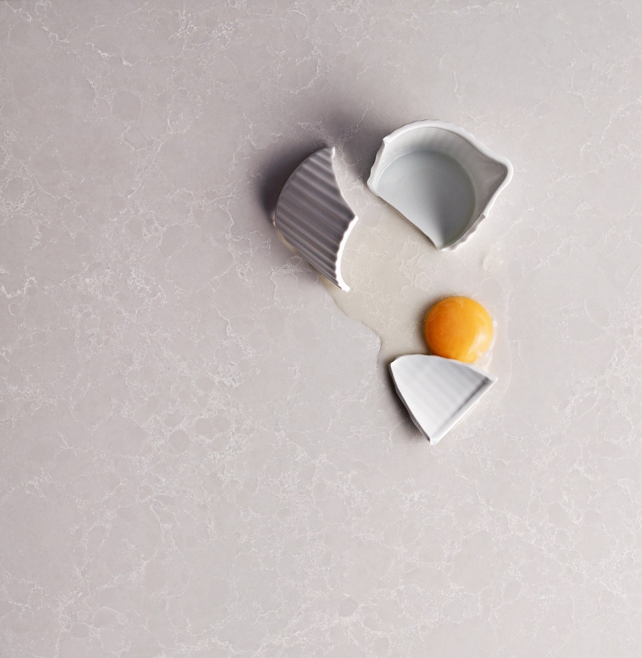 Caesarstone 5110 Alpine Mist quartz countertop with a cracked egg