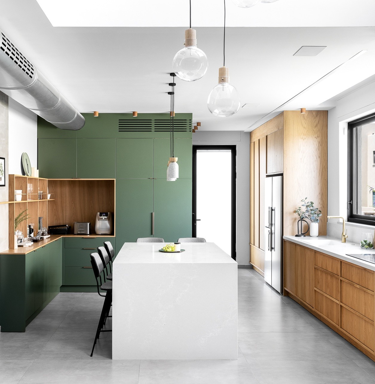 Modern kitchen with a white Caesarstone 5110 Alpine Mist island and green cabinetry.