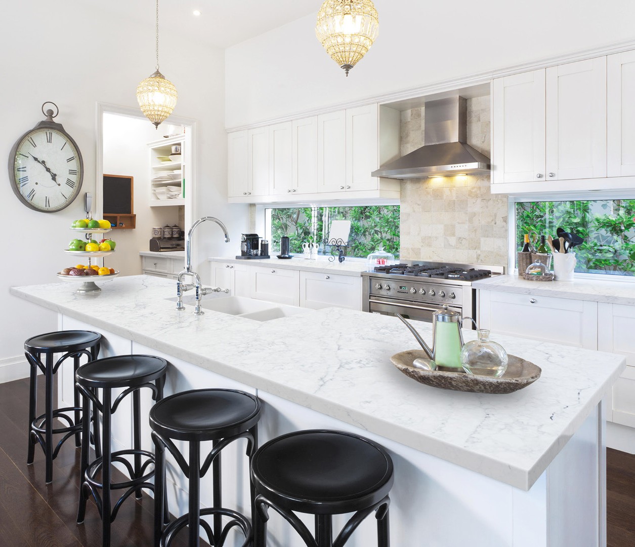 Avant Quartz 7200 Aquitaine Blanca countertop in a modern white kitchen with island and stools.