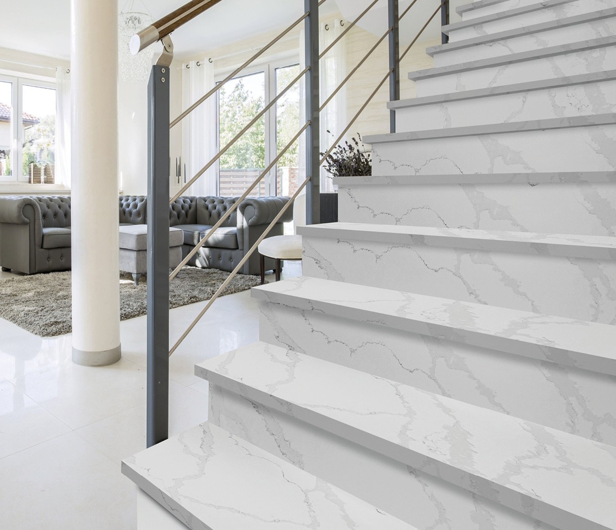 White Calacatta Bianco quartz clads the staircase in a bright living room with grey veining and glossy steps.