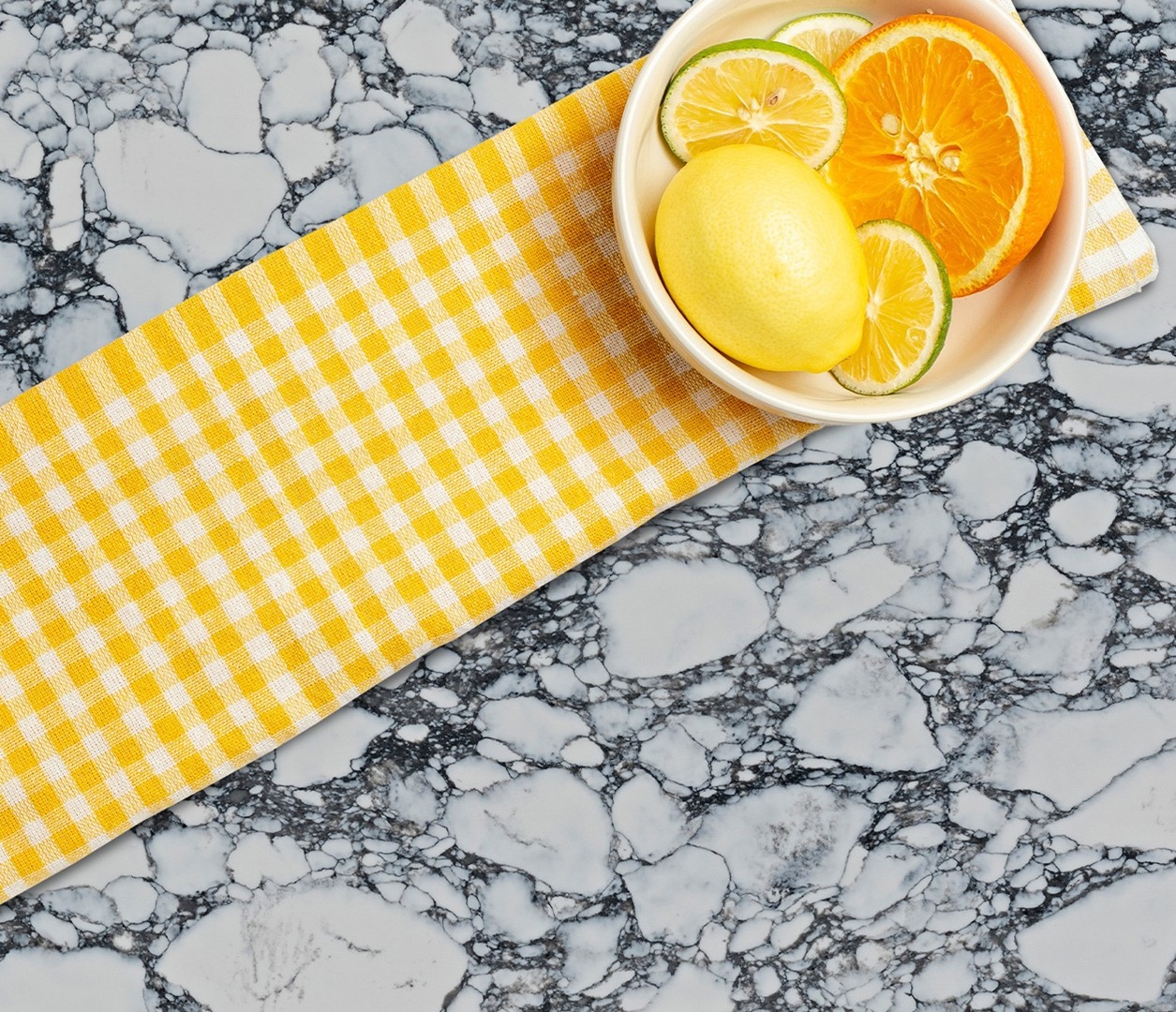 Avant Quartz 9070 Arabescato Alencon countertop with citrus fruits and yellow checkered napkin