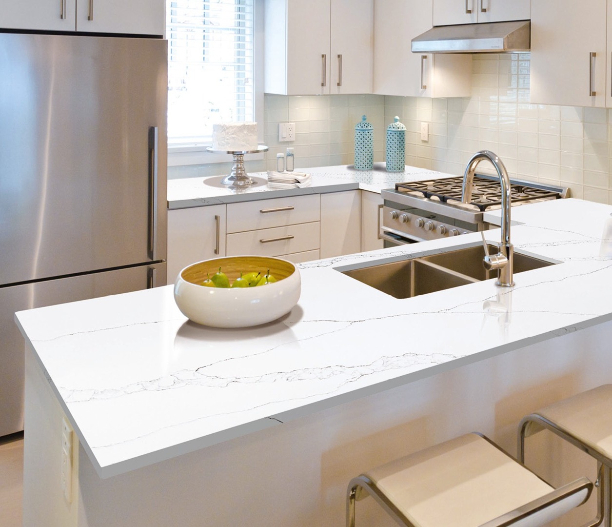 Avant Quartz 7000 Calacatta Eno countertop in a modern white kitchen with stainless steel appliances.