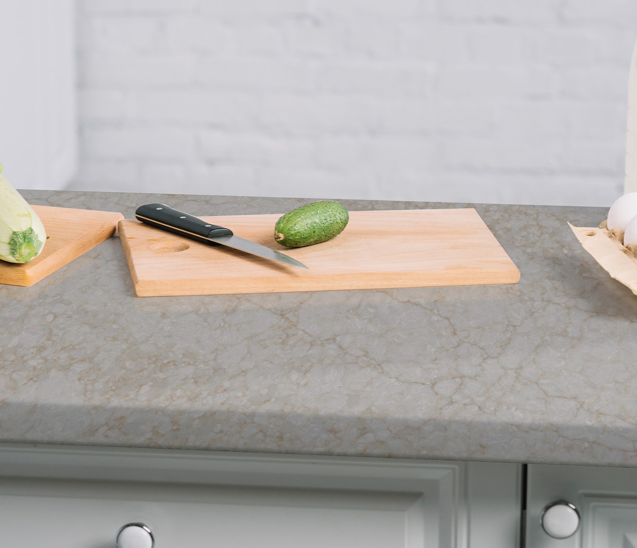 Avant Quartz 9030 Royal Beige countertop with cutting board, knife, and vegetables.